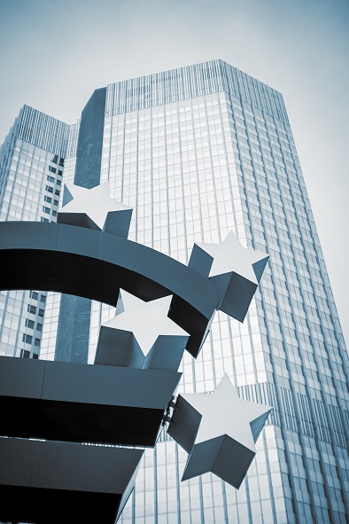 Ein Bild des Euro mit einem Wolkenkratzer im Hintergrund.